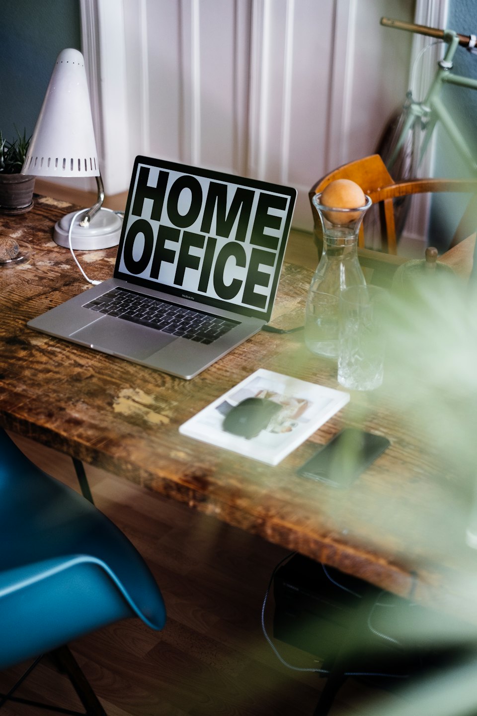 Moderner Laptop mit "Home Office"-Text auf einem rustikalen Holztisch.